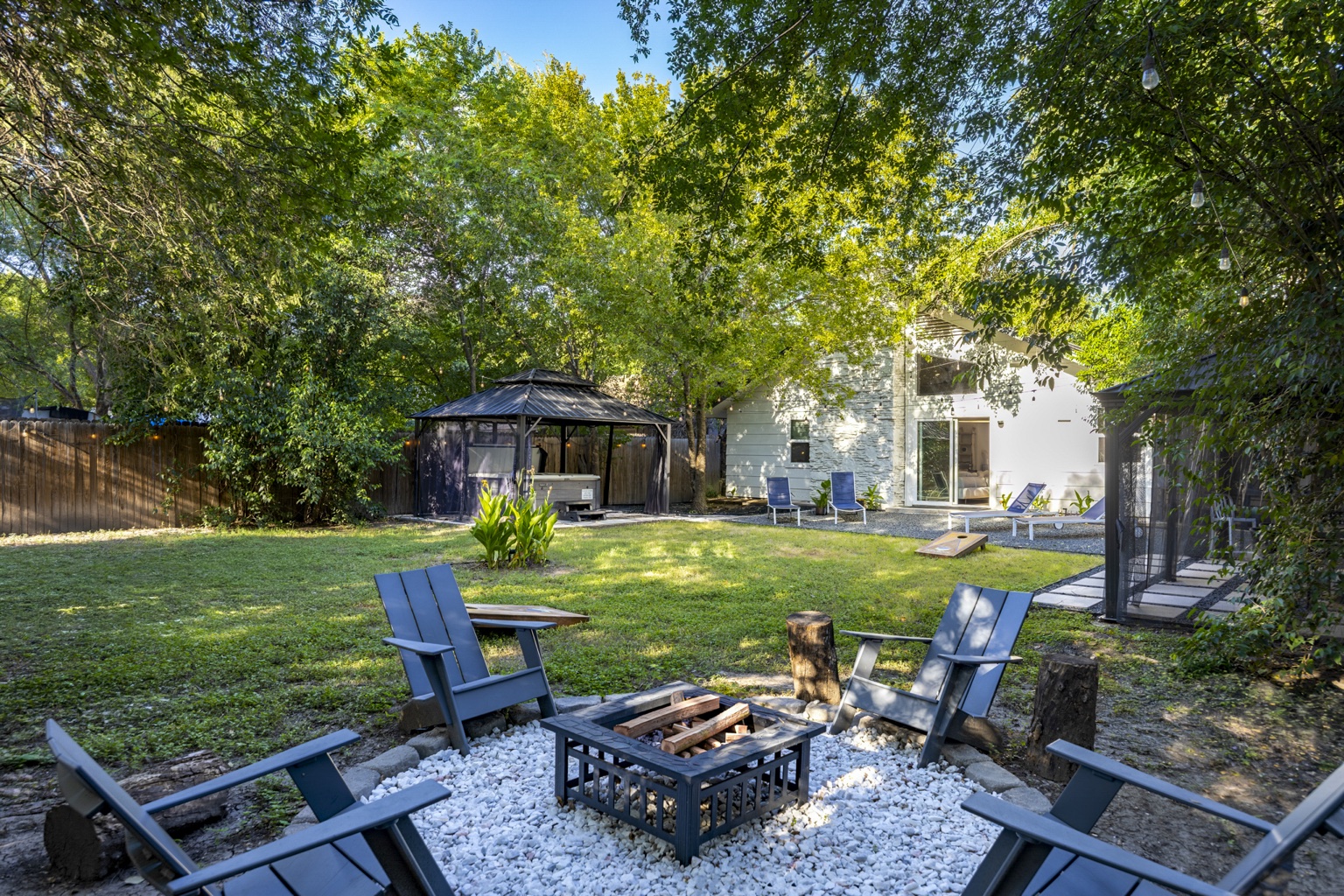 Tree-shaded backyard and fire-pit seating at Peppertree Paradise